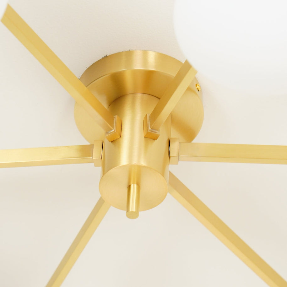 Close detail of the brushed brass centre hub and radiating arms of the Jasper Ceiling Lamp