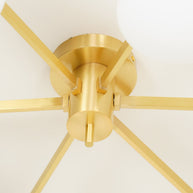Close detail of the brushed brass centre hub and radiating arms of the Jasper Ceiling Lamp