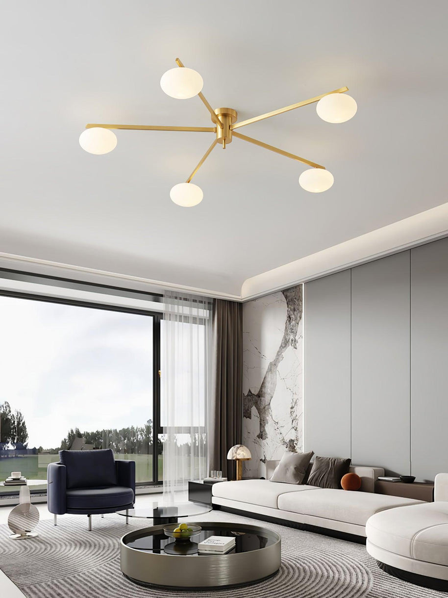 Jasper Ceiling Lamp in brass and white, installed above a seating area with a low round table