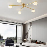 Jasper Ceiling Lamp in brass and white, installed above a seating area with a low round table