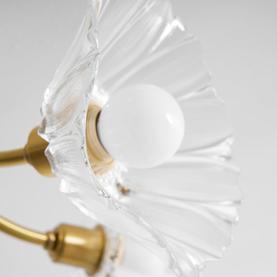 Close view of a flower shade from below, showing the brass arm and lamp holder.