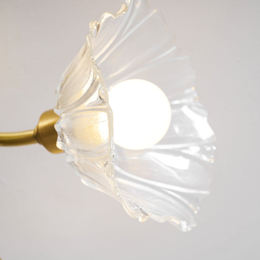 Close view of one flower-shaped glass shade with the bulb lit inside.