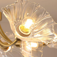 Close view of a lit bulb inside one clear flower-shaped shade.