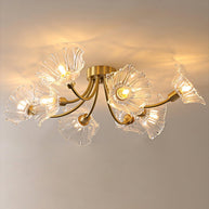 Flush-mount ceiling lamp with curved brass arms holding clear ribbed flower-shaped glass shades, lit, with the arms spread wide across the ceiling.