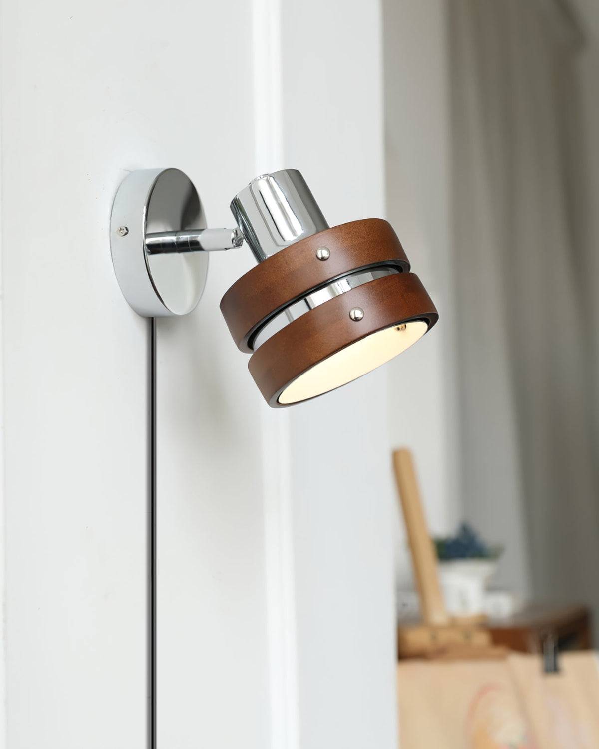 Karrivelle Wall Light, lit on a white wall, angled