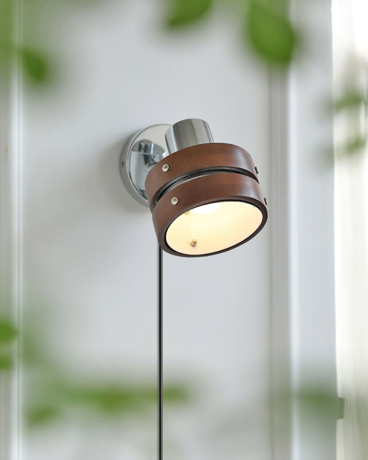 Karrivelle Wall Light, lit with soft foliage in front