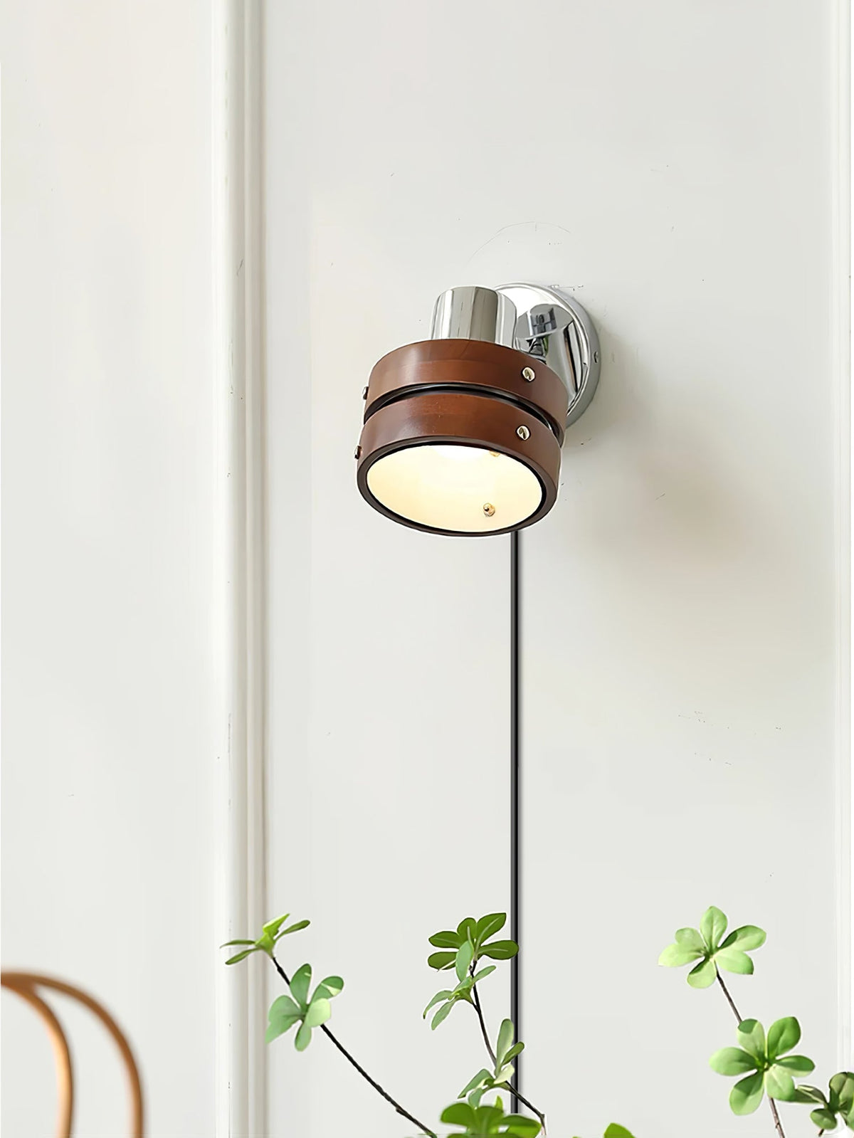 Karrivelle Wall Light, lit on a white panelled wall