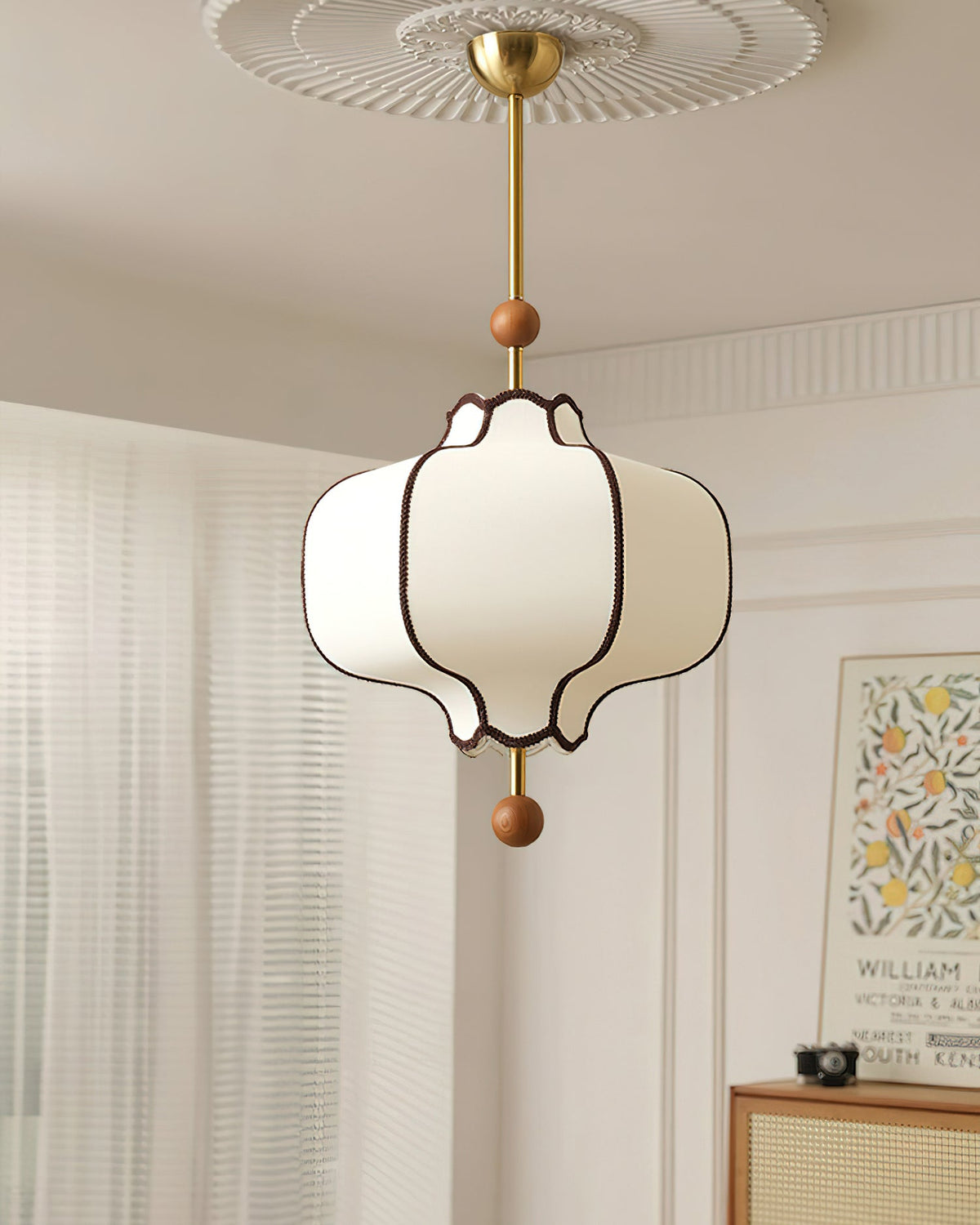 Lit white lantern pendant hanging from a fluted ceiling rose beside a cane-fronted sideboard.