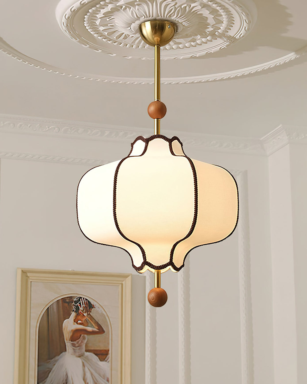 Lit white lantern pendant hanging from a plaster ceiling rose in a room with heavy cornices.