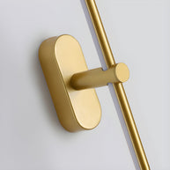 Close detail of the gold oval wall plate and pivot collar joining the slim linear bar
