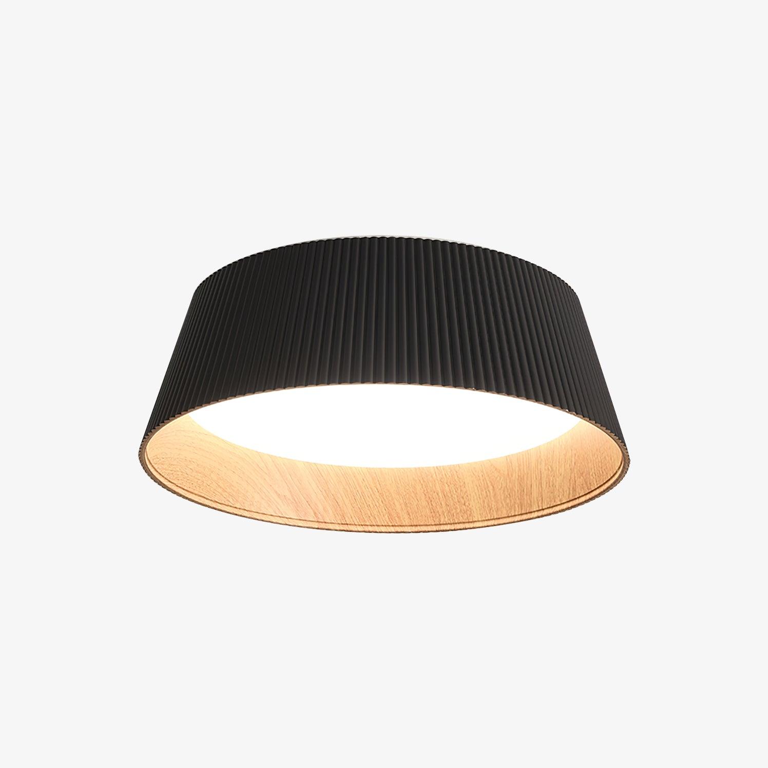 Drum-shaped flush ceiling light with a ribbed black outer, a wood-look inner rim and a white diffuser, seen from the side on a white background.