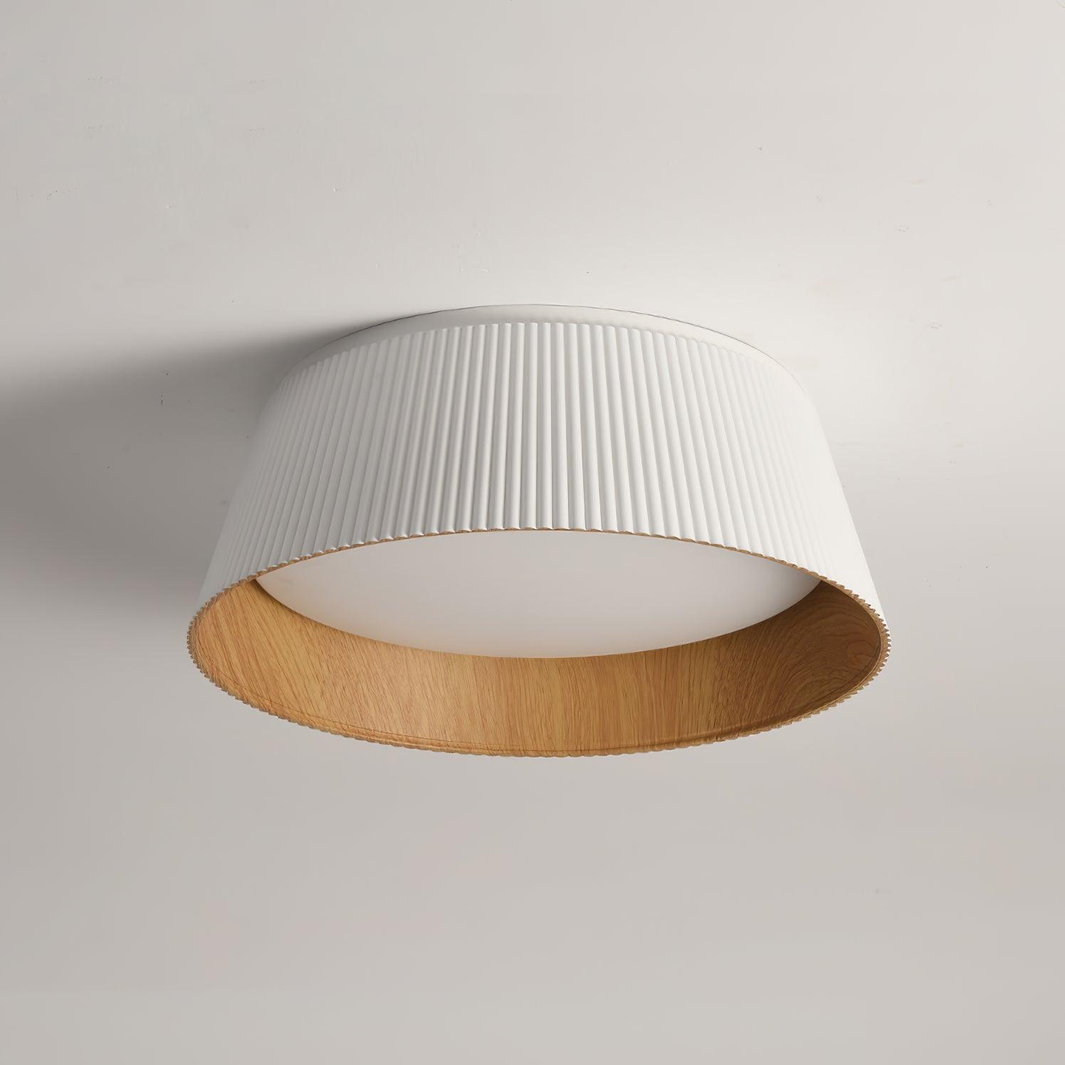 Drum-shaped flush ceiling light with a ribbed shade, a wood-look inner rim and a white diffuser, white ribbed shade, lit, seen from below on a plain background.