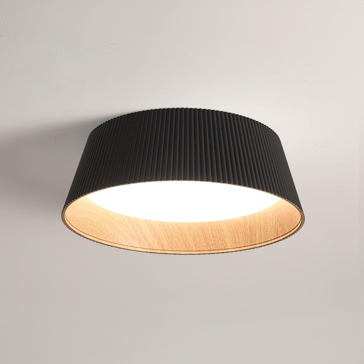 Drum-shaped flush ceiling light with a ribbed shade, a wood-look inner rim and a white diffuser, dark ribbed shade, lit, seen from below on a plain background.