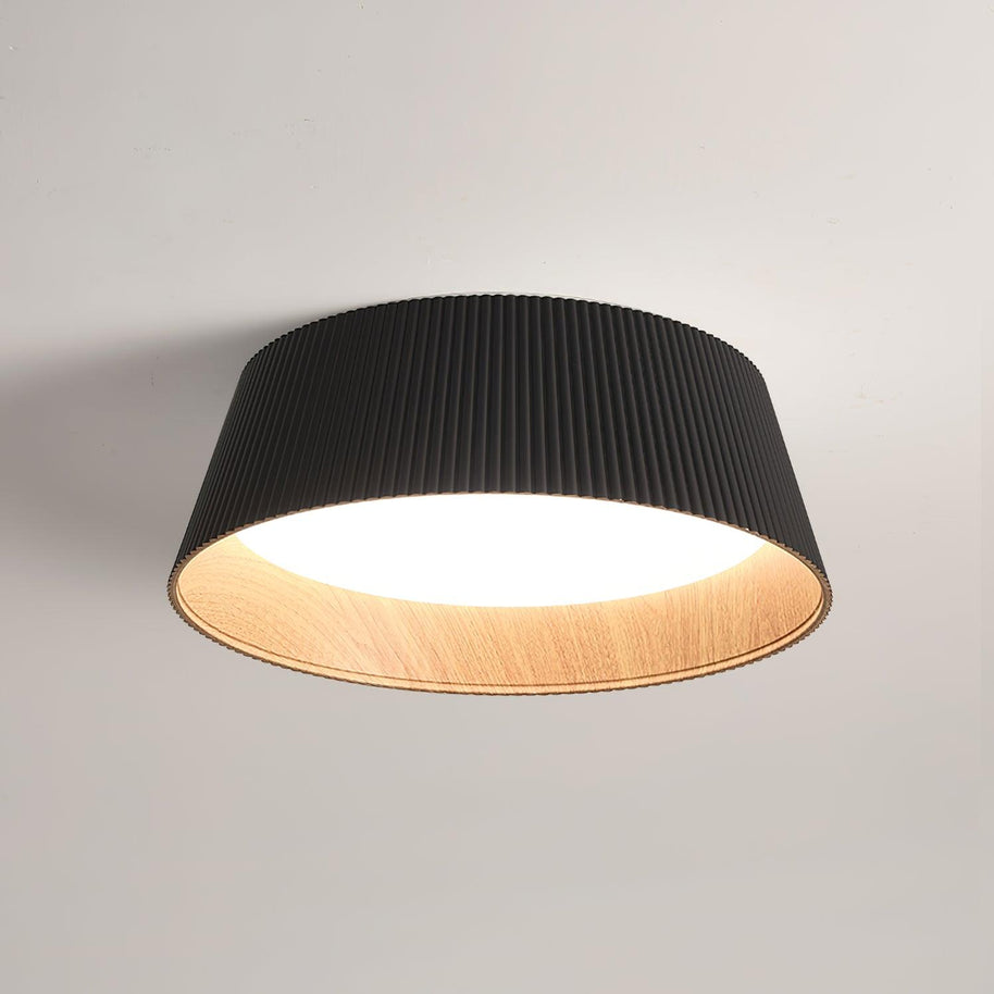 Drum-shaped flush ceiling light with a ribbed shade, a wood-look inner rim and a white diffuser, dark ribbed shade, lit, seen from below on a plain background.