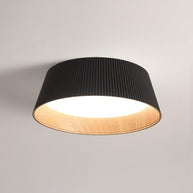 Drum-shaped flush ceiling light with a ribbed shade, a wood-look inner rim and a white diffuser, dark ribbed shade, lit, seen from below on a plain background.