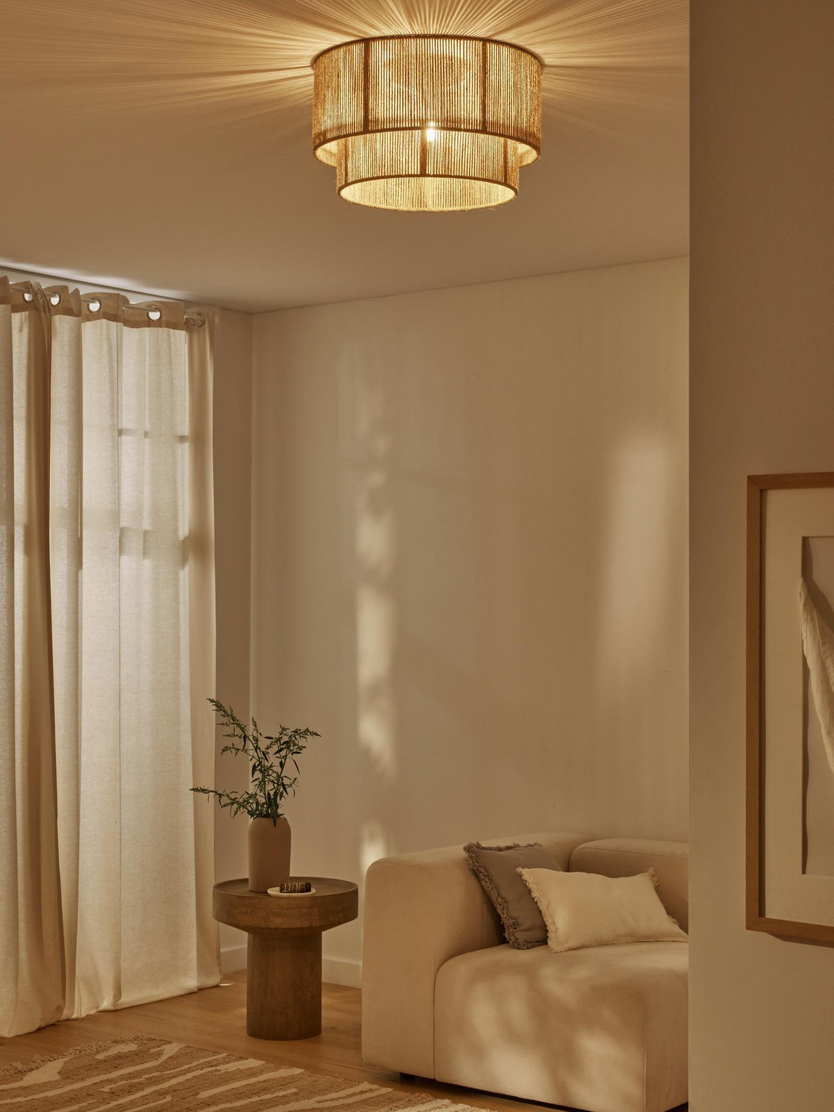 Pathella Ceiling Light, lit two-tier jute rope drum above a cream sofa