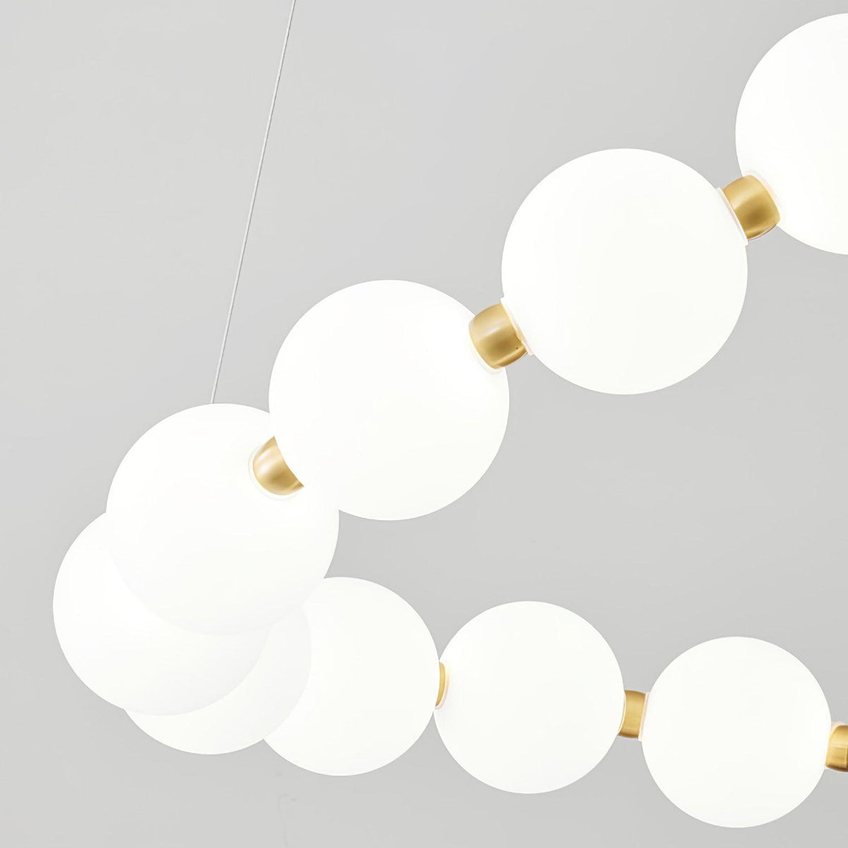 Perloria Chandelier close-up of opal glass globes and brass collars