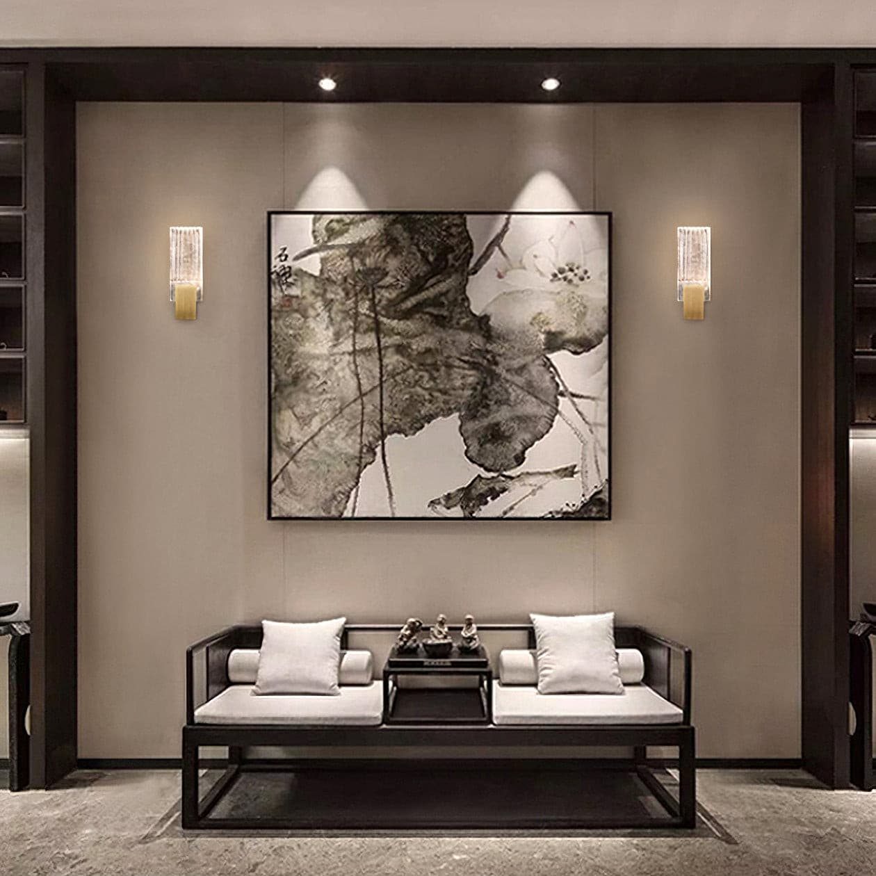 Two of the wall lights lit either side of a framed picture in a living room.