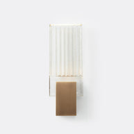 Wall light with a ribbed clear glass panel and a gold-toned metal mount, shown unlit on a white background, seen straight on.