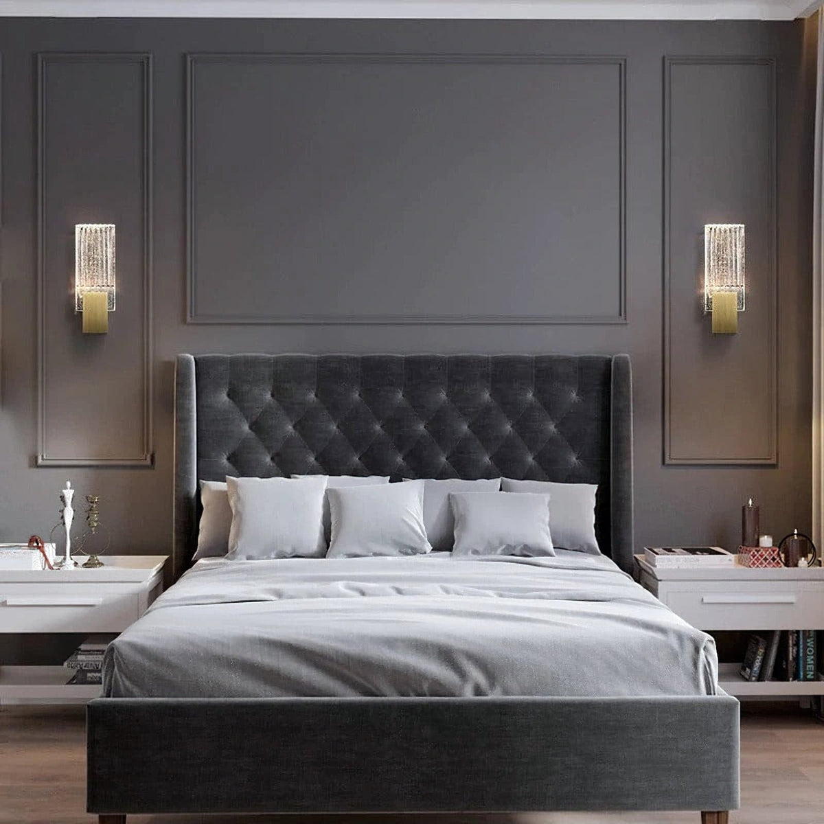 Two of the wall lights either side of a bed on a panelled wall.