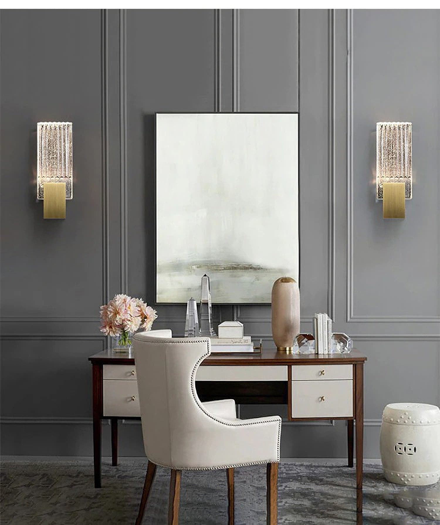 Two of the wall lights either side of a mirror above a desk.