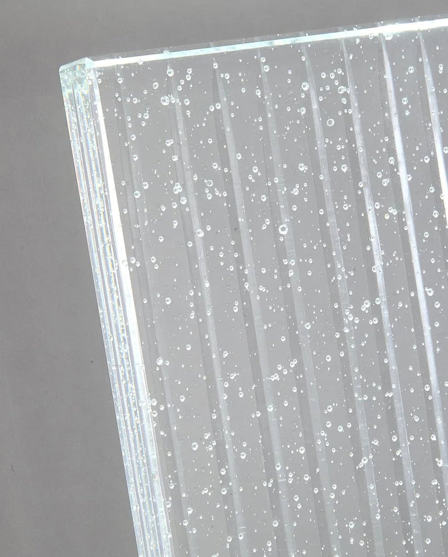 Close view of the glass panel edge showing the ribs and trapped bubbles.