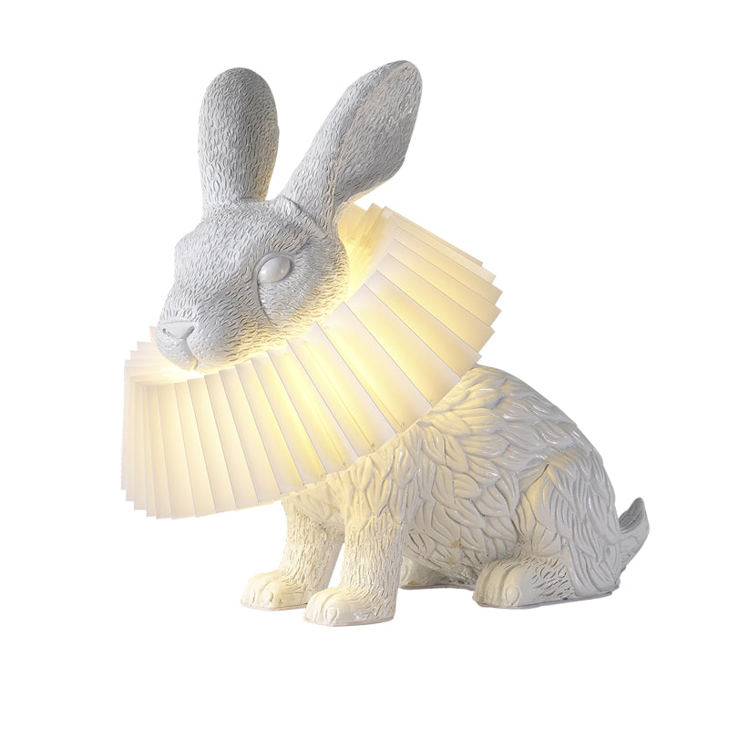 Rabellin Table Lamp - seated white leaf-textured rabbit with pleated ruff shade glowing warm, white background