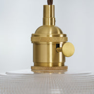 Close view of the gold-toned lamp holder and knurled collar above the glass shade.
