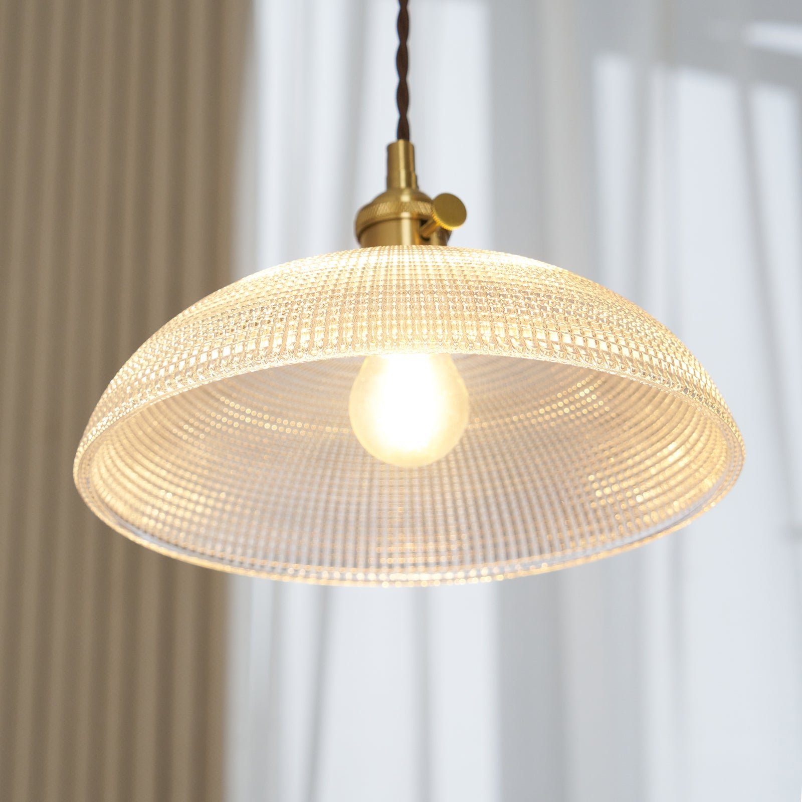 Close view of the lit shade from below, with the bulb showing through the glass.