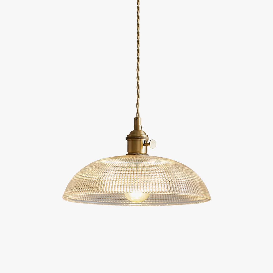 Pendant light with a ribbed glass dome shade and a gold-toned lamp holder, lit, shown on a white background with a warm glow.