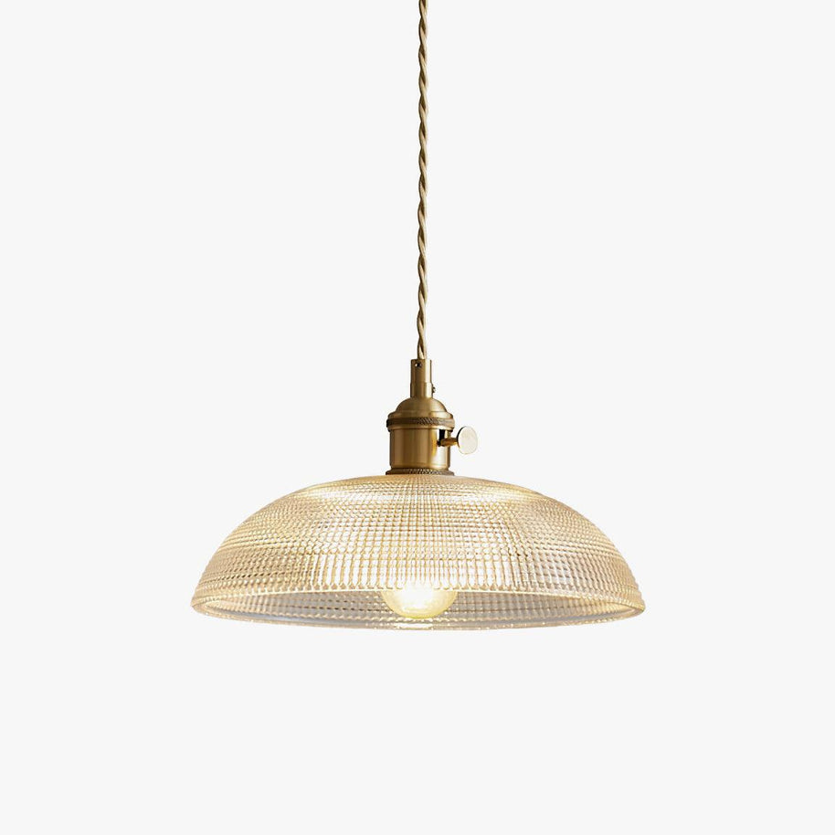 Pendant light with a ribbed glass dome shade and a gold-toned lamp holder, lit, shown on a white background with a warm glow.