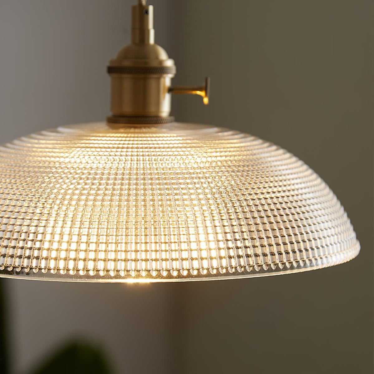 Close view of the lit shade seen from below, showing the fine dimpled pattern in the glass.
