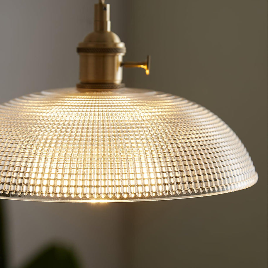 Close view of the lit shade seen from below, showing the fine dimpled pattern in the glass.