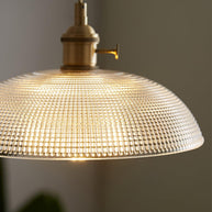 Close view of the lit shade seen from below, showing the fine dimpled pattern in the glass.