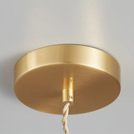 Close view of the round gold-toned ceiling plate with the twisted cable running from it.