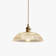 Pendant light with a ribbed glass dome shade and a gold-toned lamp holder, lit, shown on a white background with a warm glow.