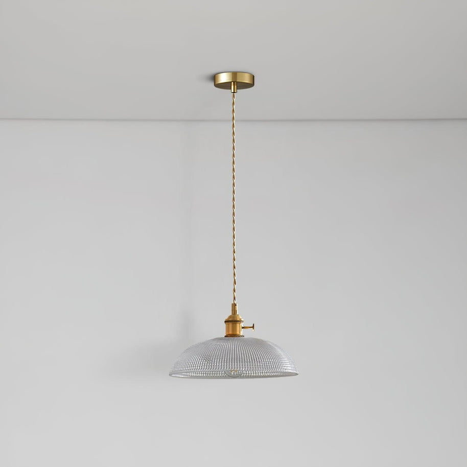 Pendant light with a ribbed glass dome shade and a gold-toned lamp holder hanging from a ceiling rose on a twisted fabric cable, unlit.