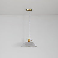 Pendant light with a ribbed glass dome shade and a gold-toned lamp holder hanging from a ceiling rose on a twisted fabric cable, unlit.