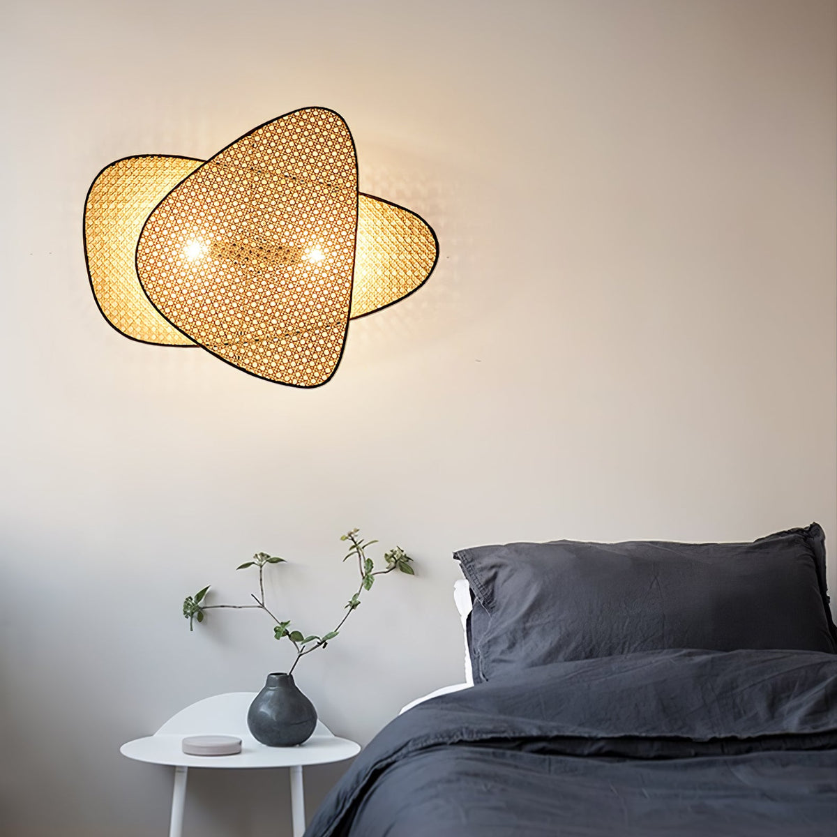 Cannelle Wall Light, two lit cane panels above a table with potted plants