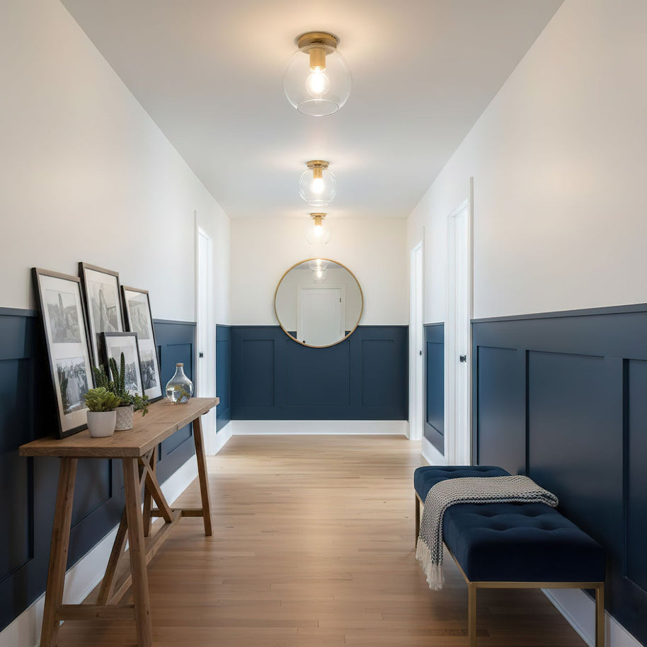 Two of the ceiling lights lit along a hallway with blue panelled walls.