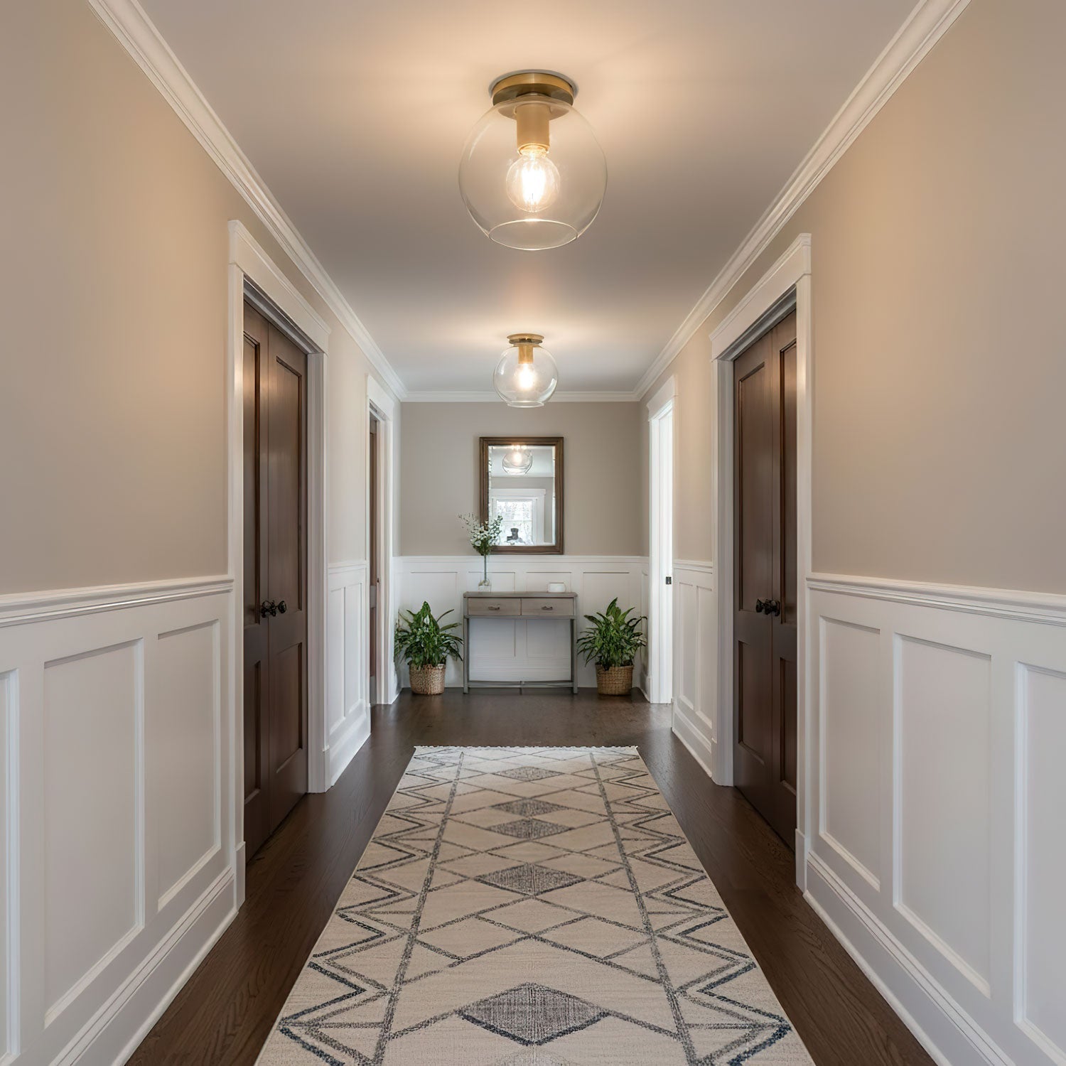 Two of the ceiling lights lit along a hallway with warm cream walls.