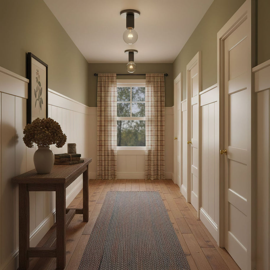 Two of the ceiling lights fitted along a hallway with olive walls.