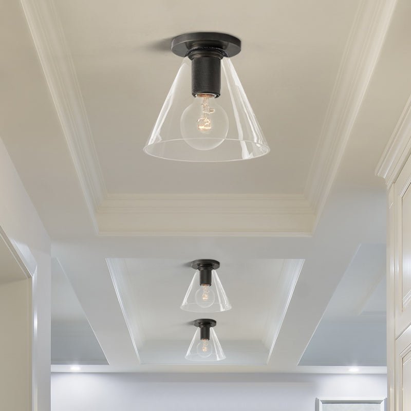 Three of the ceiling lights with dark plates and clear cone shades on a white coffered ceiling.