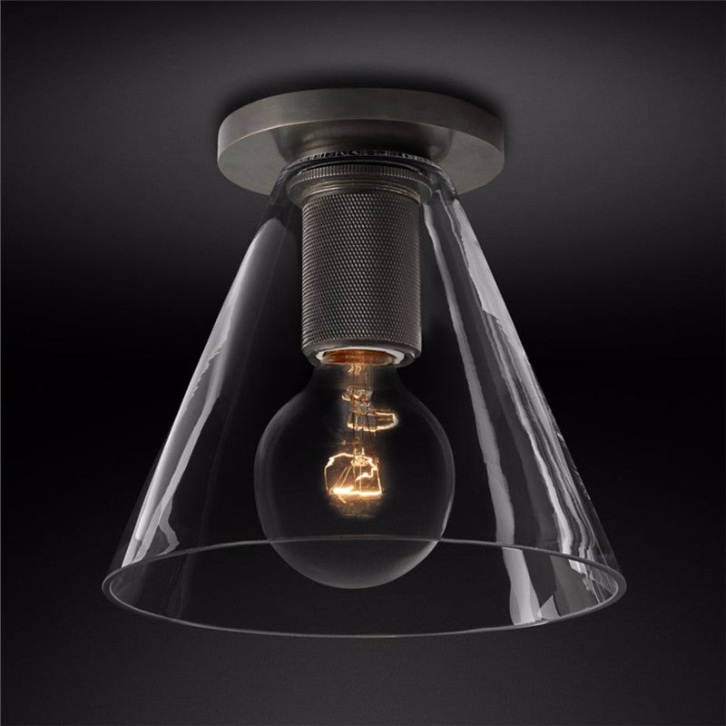 Flush-mount ceiling light with a dark ceiling plate, knurled holder and a clear cone-shaped glass shade.