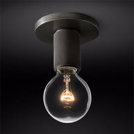 Close view of the dark ceiling plate and knurled holder with the bulb lit.