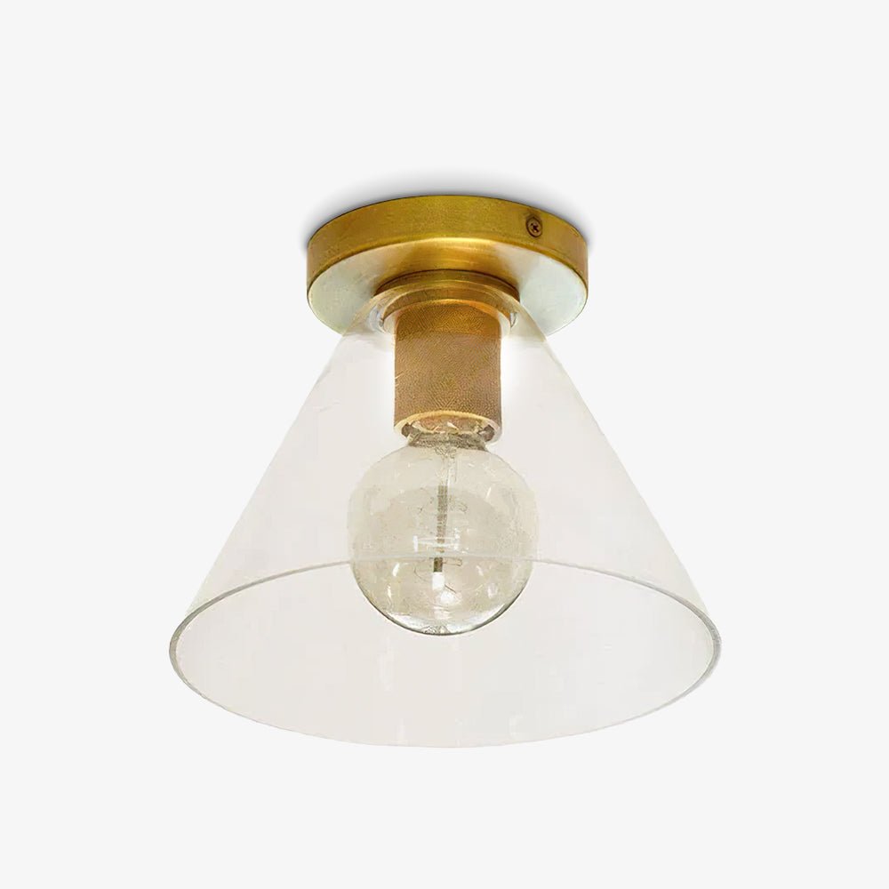 Flush-mount ceiling light with a brass plate and clear cone-shaped glass shade, shown close on white.