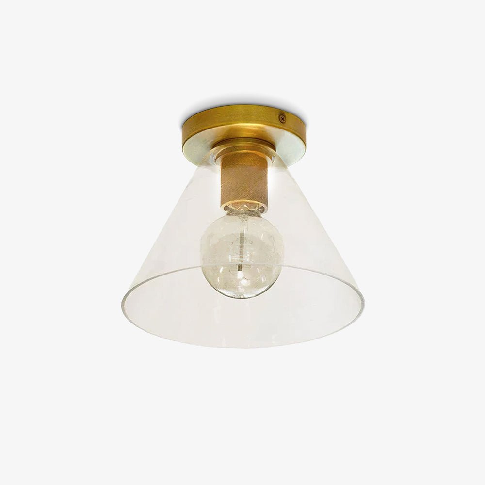 Flush-mount ceiling light with a brass plate and clear cone-shaped glass shade, on a white background.