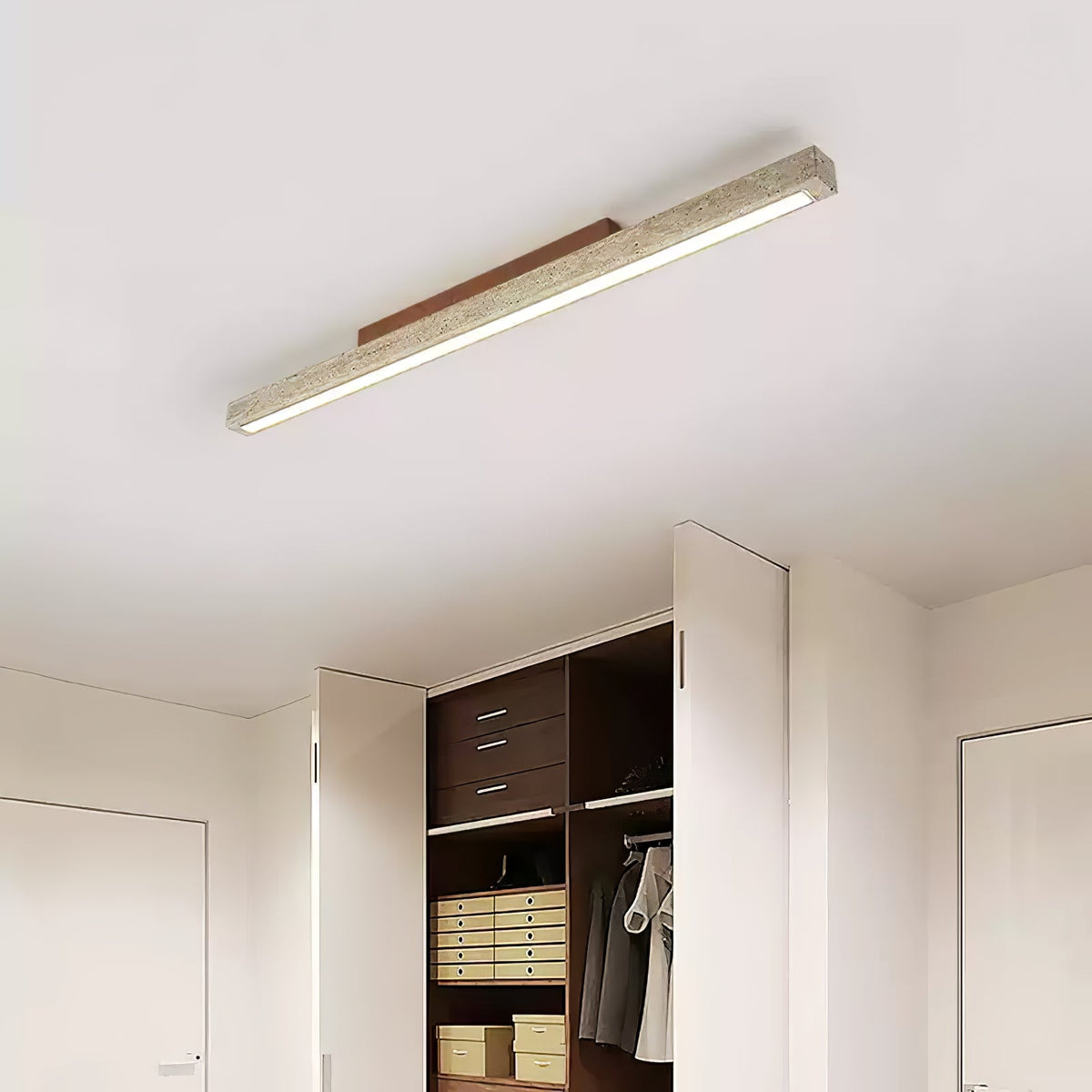 Travellin Ceiling Light, travertine bar with dark walnut mount lit above an open wardrobe