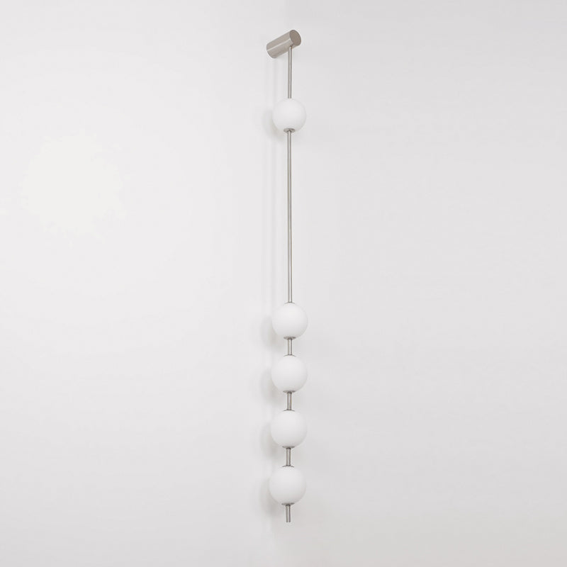 Wall lamp with a vertical row of white ball shades on a slim pale grey rod, unlit, on a white background.