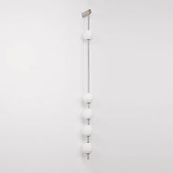 Wall lamp with a vertical row of white ball shades on a slim pale grey rod, unlit, on a white background.